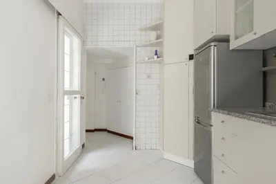 a white kitchen with a sink and a refrigerator at La Dolce Vita - Elegant retreat in the heart of Rome in Rome