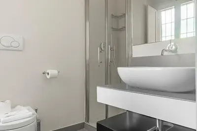 a white bathroom with a sink and a mirror at La Dolce Vita - Elegant retreat in the heart of Rome in Rome