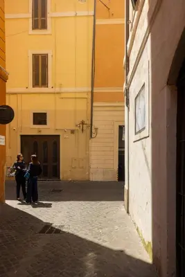 two people standing in an alley next to a building at La Dolce Vita - Elegant retreat in the heart of Rome in Rome