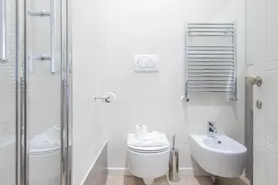 a white bathroom with a toilet and a sink at La Dolce Vita - Elegant retreat in the heart of Rome in Rome