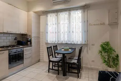 a kitchen with a table and chairs in a room at GuestHost - Comfy Apartment X2 in Monteverde in Rome