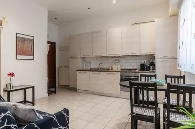 a kitchen with white cabinets and a table at GuestHost - Comfy Apartment X2 in Monteverde in Rome