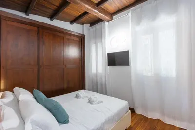 a bedroom with a white bed and a wooden wall at Vicolo Trevi Apartment by Rental in Rome in Rome