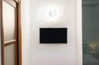 a television on the wall of a room at Vicolo Trevi Apartment by Rental in Rome in Rome