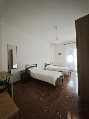 a white room with two beds and a tv at Large Apartment in Garbatella Near the Center of Rome in Rome