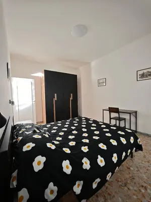 a bedroom with a black bed with white flowers on it at Large Apartment in Garbatella Near the Center of Rome in Rome