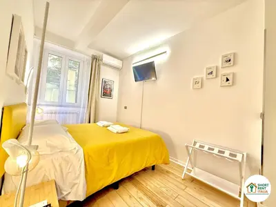 a bedroom with a yellow bed and a window at Colosseo - Venus House in Rome