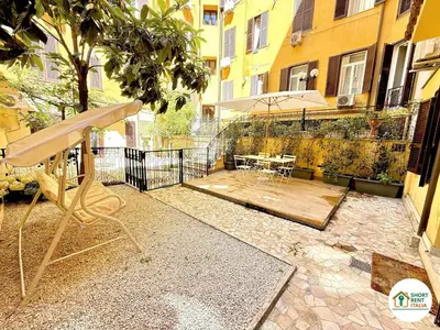 a patio with a table and an umbrella on a building at Colosseo - Venus House in Rome