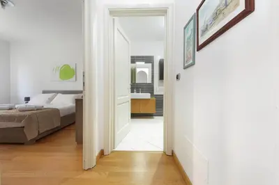 a hallway leading to a bedroom with a bed and a mirror at 4BNB - Porta Portese Cozy Apartment in Rome