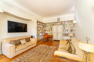 a living room with two couches and bookshelves at Luxury Suite Dante Elegante Appartamento di Lusso nel Cuore di Roma in Rome