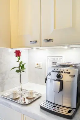 a coffee maker and a vase with a flower on a kitchen counter at Luxury Suite Dante Elegante Appartamento di Lusso nel Cuore di Roma in Rome