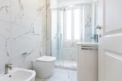 a white bathroom with a toilet and a shower at Constance Terrace Apartment by Rental in Rome in Rome