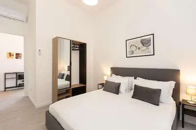 a bedroom with a large white bed and a mirror at Constance Terrace Apartment by Rental in Rome in Rome