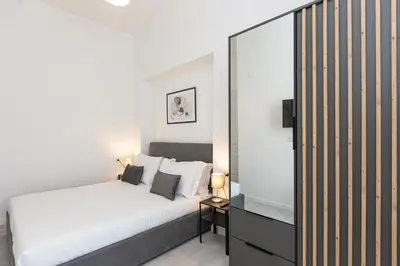 a bedroom with a white bed and a mirror at Constance Terrace Apartment by Rental in Rome in Rome