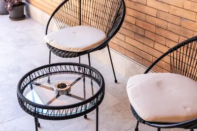 two chairs and a coffee table on a patio at Constance Terrace Apartment by Rental in Rome in Rome