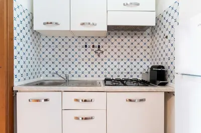 a kitchen with white cabinets and a sink at Domus Sabelli in Rome
