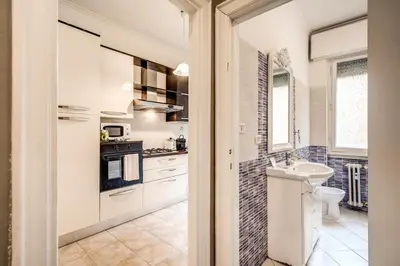 a kitchen with white cabinets and a sink at Large Apartment in San Giovanni A in Rome