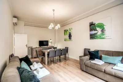 a living room with a couch and a dining room at Large Apartment in San Giovanni A in Rome