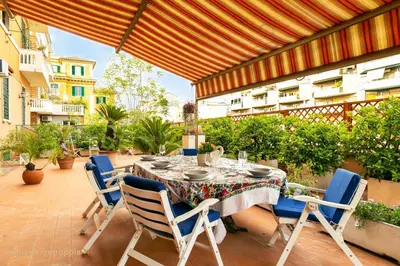 a table and chairs on a patio with an umbrella at Trastevere Art House & terrace in Rome