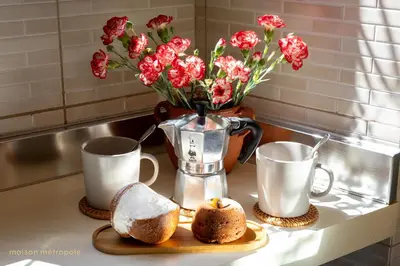 a table with two cups and a vase with flowers at Trastevere Art House & terrace in Rome