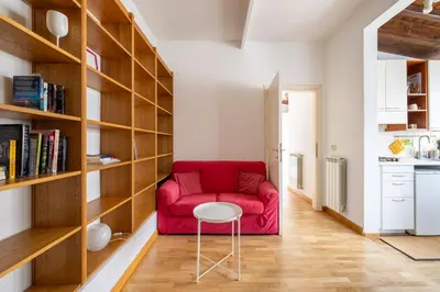 a living room with a red couch and a stool at Piazza Navona Rooftop Retreat S in Rome