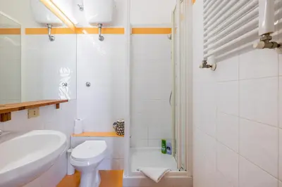 a white bathroom with a toilet and a sink at Piazza Navona Rooftop Retreat S in Rome