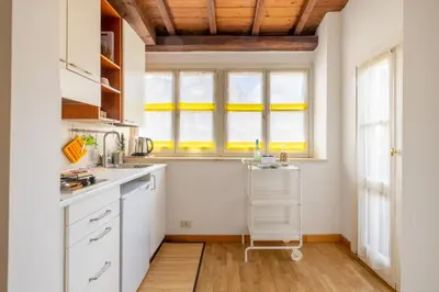 a kitchen with white cabinets and a sink at Piazza Navona Rooftop Retreat S in Rome