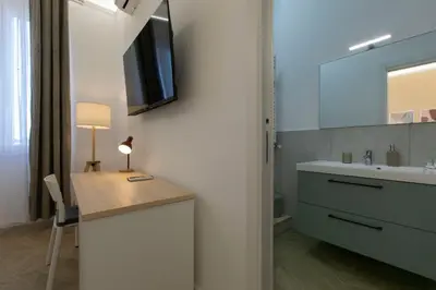 a bathroom with a sink and a desk with a mirror at Nomentana Home in Rome
