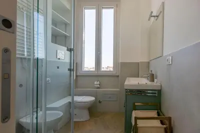 a bathroom with a toilet and a sink and a window at Nomentana Home in Rome