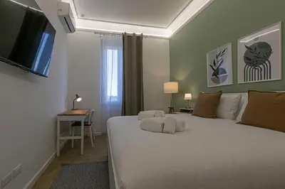 a bedroom with a large white bed with a flat screen tv at Nomentana Home in Rome