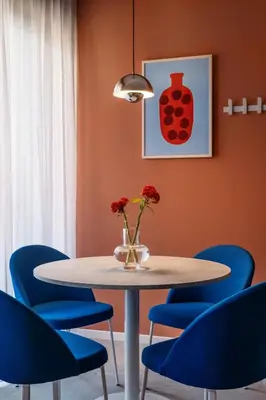 a dining room with a table and blue chairs at Numa Rome Trastevere in Rome