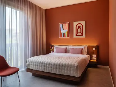 a bedroom with a bed and a red wall at Numa Rome Trastevere in Rome