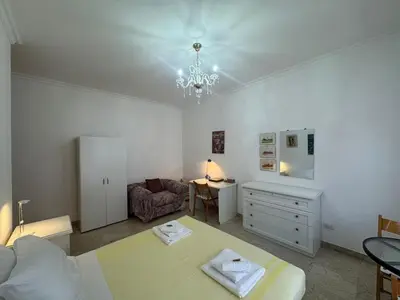 a living room with a chandelier and a table and a couch at Rome in Retro Style in Rome
