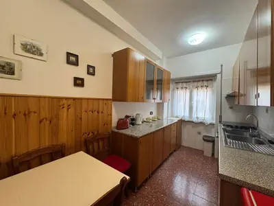 a kitchen with wooden cabinets and a sink at Rome in Retro Style in Rome