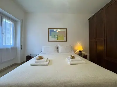 a bedroom with a large white bed with two towels at Rome in Retro Style in Rome