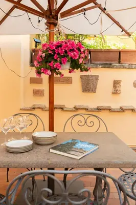 a table with pink flowers on top of it at the secret terrace - navona in Rome