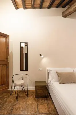 a bedroom with a bed and a chair and a mirror at the secret terrace - navona in Rome