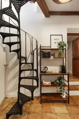 a black spiral staircase in a living room at the secret terrace - navona in Rome