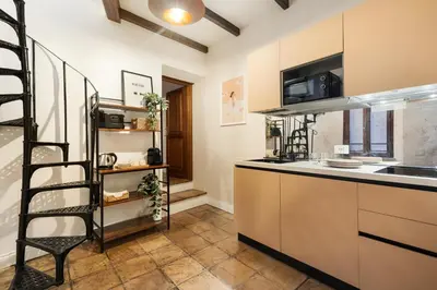 a kitchen with a spiral staircase in a room at the secret terrace - navona in Rome