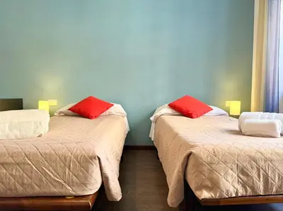 a room with two beds with red pillows on them at Oasi Majorana in Rome