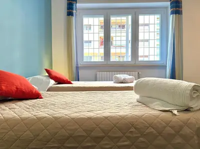 two beds in a room with a window at Oasi Majorana in Rome