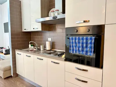 a kitchen with white cabinets and a stove top oven at Oasi Majorana in Rome
