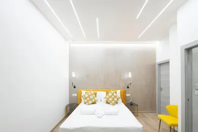 a bedroom with a bed and a yellow chair at Olimpico Luxury Rooms in Rome