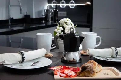 a table with two plates of food and a tea kettle at Melodies Of Rome in Rome