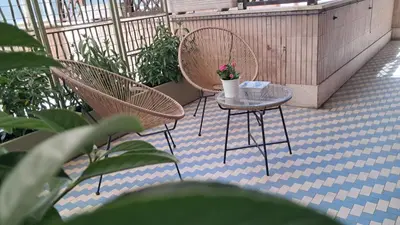 a patio with two chairs and a table with flowers at Melodies Of Rome in Rome