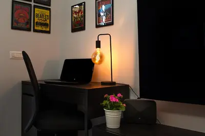 a desk with a laptop and a lamp on it at Melodies Of Rome in Rome