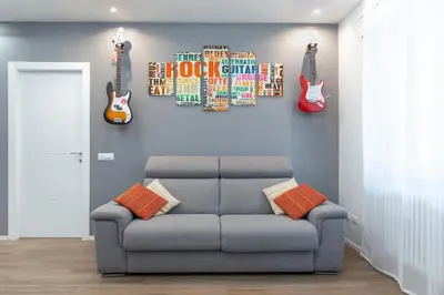 a living room with a couch and guitars on the wall at Melodies Of Rome in Rome