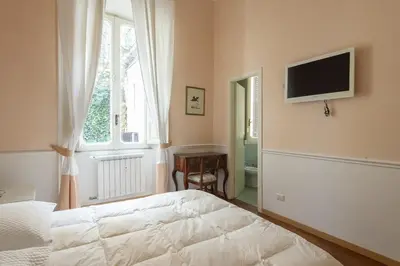 a bedroom with a bed and a television on the wall at Vatican Luxury Three Bedroom Apartment in Rome