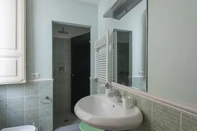 a bathroom with a sink and a mirror at Vatican Luxury Three Bedroom Apartment in Rome