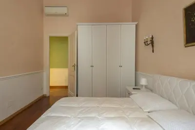 a bedroom with a white bed and a closet at Vatican Luxury Three Bedroom Apartment in Rome